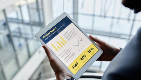 Cara Mengatur Keuangan dengan Aplikasi melalui tablet yang menampilkan laporan keuangan dan grafik pengeluaran